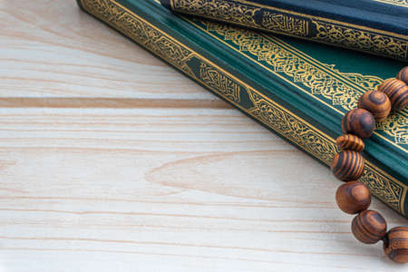 Holy Quran with arabic calligraphies translation meaning of Al-Quran and Rosary or Tasbih on wooden background. Ramadan,Hajj, Islamic and Copy Space conceptの写真素材