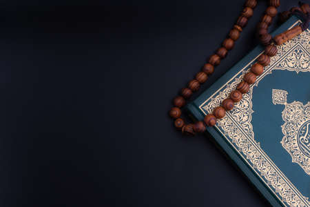 Holy Quran with arabic calligraphies translation meaning of Al-Quran and Rosary or Tasbih on black background. Ramadan,Hajj, Islamic and Copy Space conceptの写真素材
