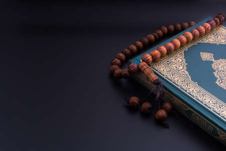 Holy Quran with arabic calligraphies translation meaning of Al-Quran and Rosary or Tasbih on black background. Ramadan,Hajj, Islamic and Copy Space conceptの写真素材