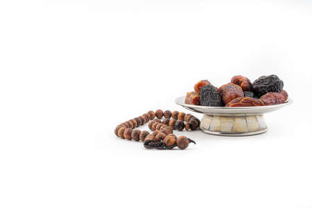 Dates or kurma fruits and rosary beads or Tasbih on white background. Ramadan Kareem and Islamic Conceptの写真素材