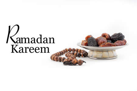 RAMADAN KAREEM text with Dates or kurma fruits and rosary beads or Tasbih on white background. Ramadan Kareem and Islamic Conceptの写真素材
