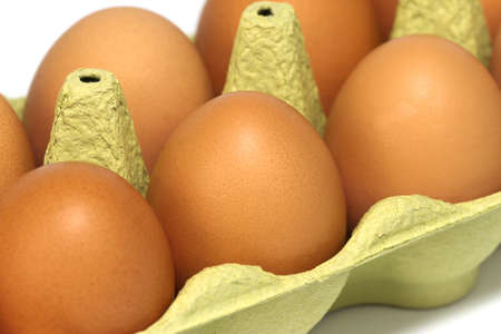 Fresh eggs in a carton, close-up.