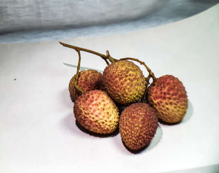 A store has ripe litchi on a white background. It is a very testy fruits. This is a picture of the...