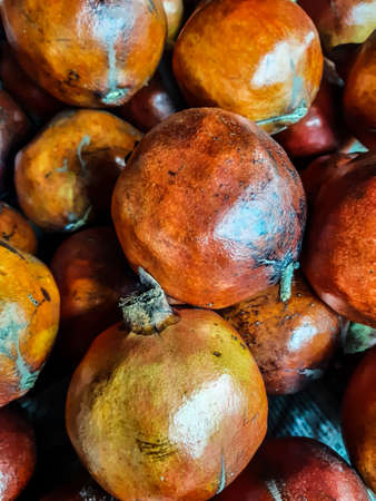 There are many together in the red-yellow ripe pomegranate basket. These are put up for sale in front of a store.の写真素材