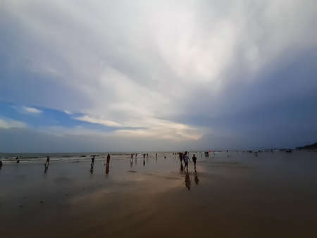 The beauty of India's long sea at sunset. Black clouds in the blue sky and the reflection of red sunlight.の写真素材
