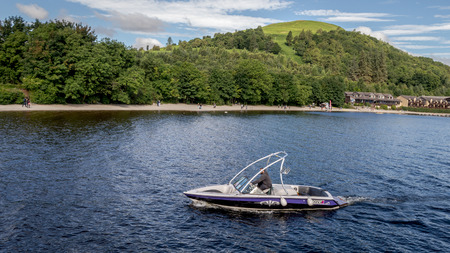 Loch Lomond, Glasgow, Scotland - 29 July, 2016 : A man with a speed boat at Lake Lomond looking for tourists interrested for a ride, Lake Lomond, Scotlandのeditorial素材