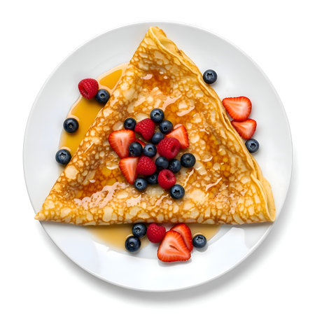 Folded triangular crepe topped with glossy syrup, fresh strawberries, blueberries, and raspberries on white plate, vibrant, detailed, cinematic, 4K.の写真素材