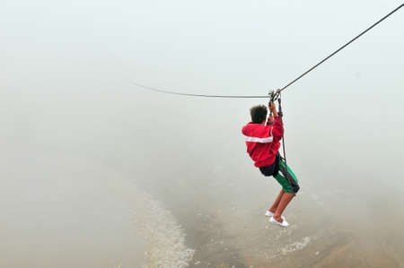 El Filo, Merlo, San Luis, Argentina - February 2, 2009: A young man throws himself down the "zip line" at El Filo, the highest point in the city of Merlo in the Province of San Luis in Argentina.のeditorial素材