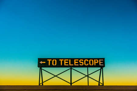 "To Telescope" sign against a clear sunset sky.の写真素材