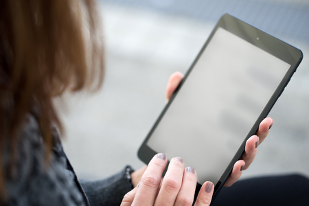 pretty young woman using black tablet with handsの写真素材