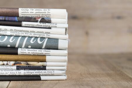 Variety of daily newspaper issues with wood in backgroundの写真素材