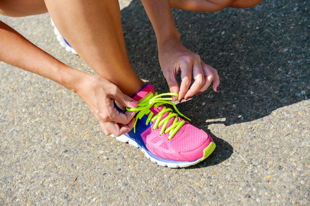 Sporty woman tying her atheltic shoesの写真素材
