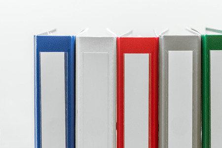 Closeup of group of colourful folders in a row on the right side of white backgroundの写真素材