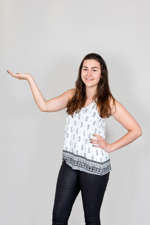 Studio shot of young woman presenting with her hand palms upの写真素材