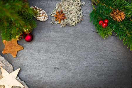 Top view of christmas decoration draped as frame on top of black shale as templateの写真素材