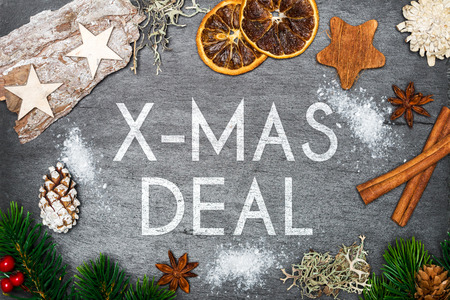 Top view of christmas decoration with snow on top of black shale with christmas deal writingの写真素材
