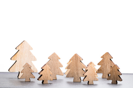 Carved wooden fir trees forming winter forest in front of white background as templateの写真素材