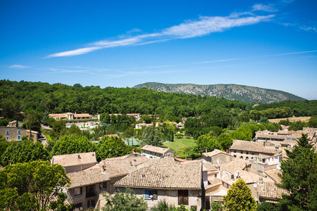 Panorama of houses, trees, blue sky and roofs with tiles of french city Malauceneの写真素材