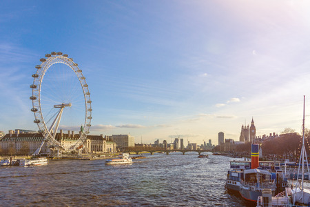 Cityscape of London with big giant wheel, River Thames and Houses of Parliament with Big Ben against blue skyのeditorial素材