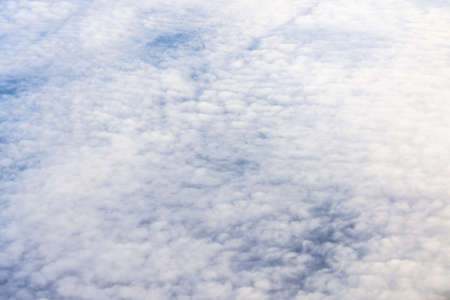 Beautiful white fluffy clouds from above out of airplane