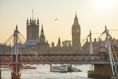 Houses of Parliament and Big Ben with river Thames and Golden Jubilee Bridges at sunset with warm colors in London, United Kingdomのeditorial素材