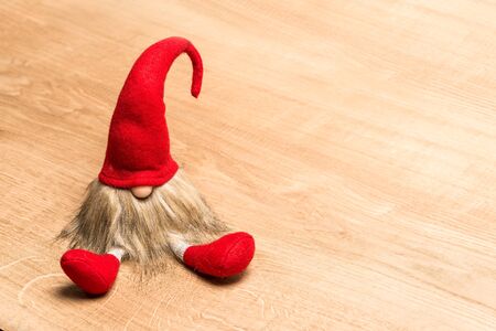 Red sitting christmas elf with pointed cap isolated as templateの写真素材