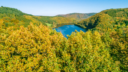 Bird's eye view over beautiful landscape with a lake and green forest from above taken by a droneの写真素材