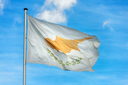 Closeup of single cypriot flag waving in the wind in front of blue skyの写真素材