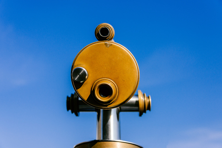 Old vintage looking metal touristic telescope at viewpoint for viewing and observation at travel...