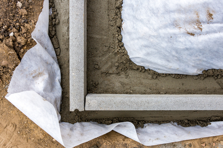 Setting edge restraints buy putting border curb stones in earth-moist concreteの写真素材