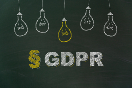 GDPR written with chalk and yellow and white light bulbs painted on dirty green chalkboardの写真素材