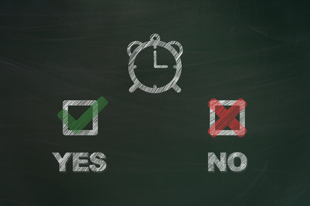 Yes and no written with chalk and painted checkboxes with clock on green chalkboard symbolizing the european union survey concerning the summertime arrangementsの写真素材