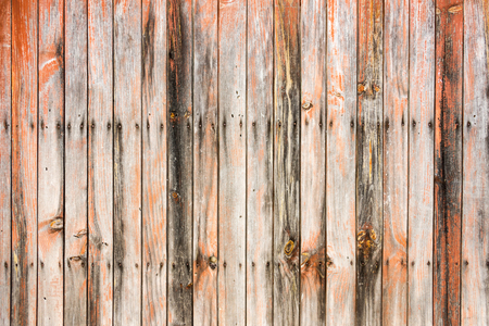 Weathered old worn wooden textured planks for wall or floor in brown and orange with rusty nails as backgroundの写真素材