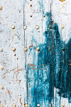 Weathered old worn wooden textured planks for wall or floor in white and blue with rusty nails as backgroundの写真素材