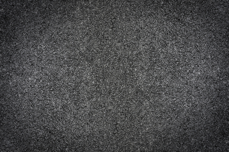 Black street asphalt closeup of road with grainy texture as backgroundの写真素材