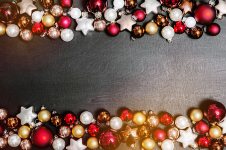 Christmas bulbs decoration as frame with copy space for happy new year message against black background as flatlay from aboveの写真素材