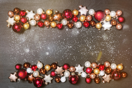 Christmas bulbs decoration as frame with copy space for happy new year message against black background as flatlay from aboveの写真素材