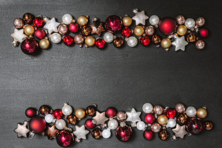 Christmas bulbs decoration as frame with copy space for happy new year message against black background as flatlay from aboveの写真素材