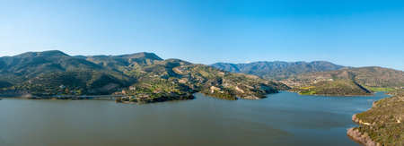 Panoramic view of lakeside with houses, road and bridgeの写真素材