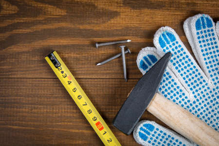Hammer, nails, roulette (tape measure) and construction gloves  on a wooden backgroundroulette and construction glovesの写真素材