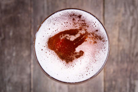 Beer in glass. Beer foam. View from above on dark wooden tableの写真素材