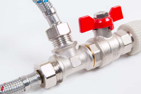 Plumbing gate ball vales, flexible water hose and fittings on a white background