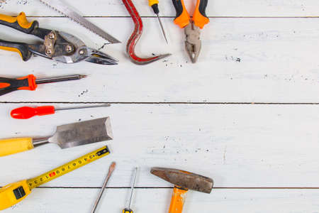 Old hand construction tools on a wooden surface.