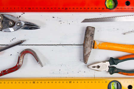 Old hand construction tools on a wooden surface.
