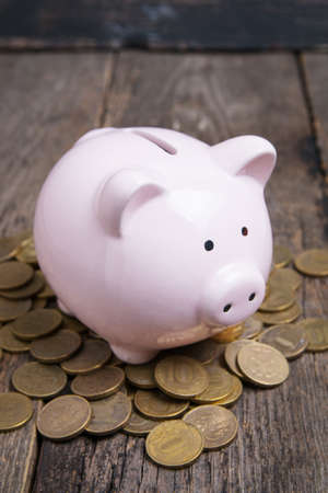 piggy bank with coin on wooden tableの写真素材