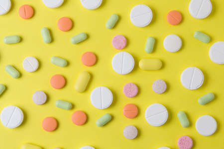 medicines pills, drugs and antibiotics on a yellow background. Drugs top view.の写真素材