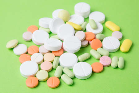 Medicines pills, drugs and antibiotics on a green background. Medicine and health care.の写真素材
