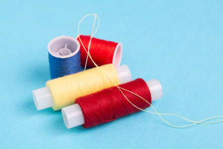 colored spools of sewing thread on a blue background