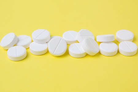 white pills on a yellow backgroundの写真素材