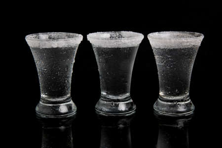 shot of tequila with salt on a black background